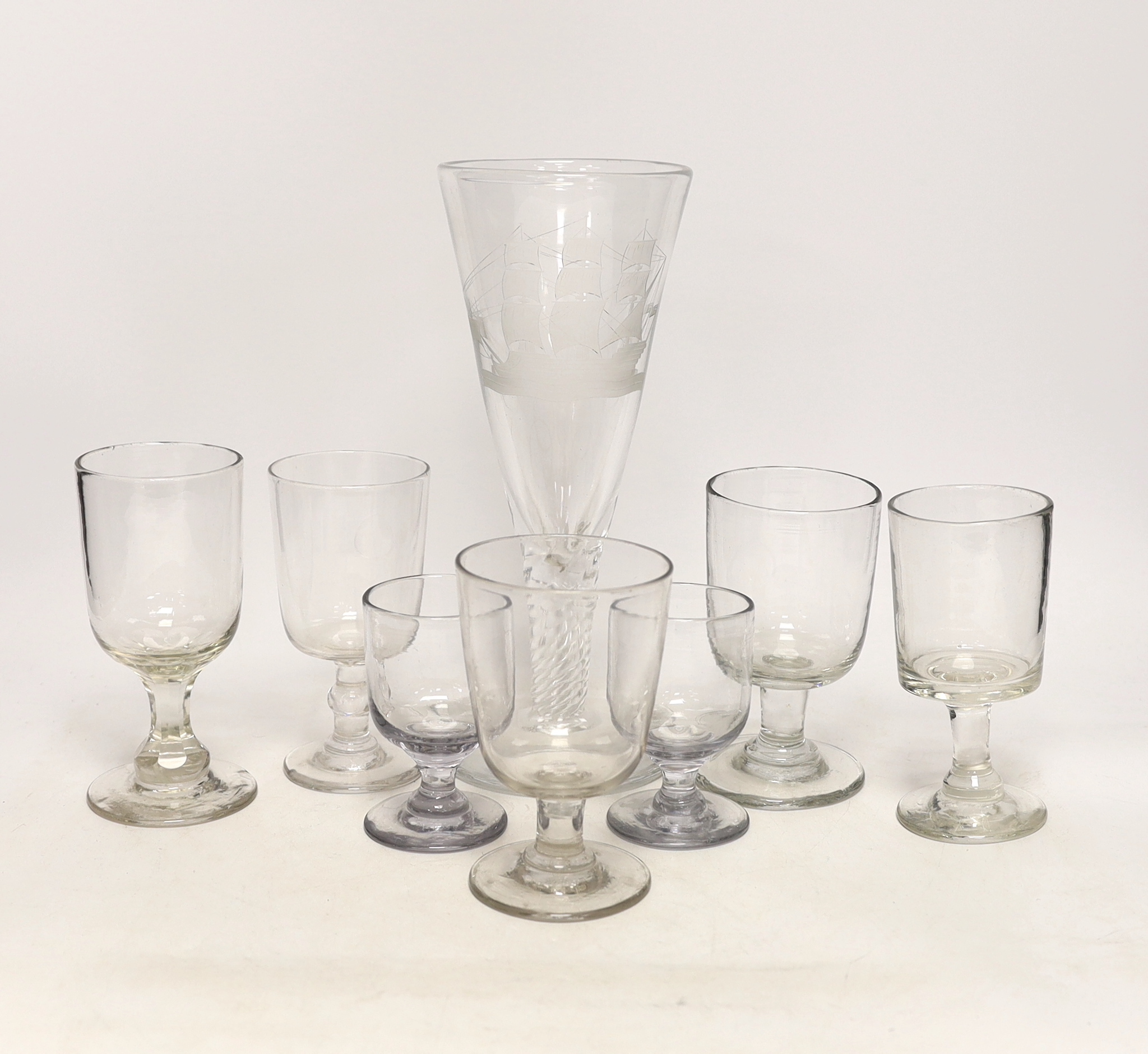 Eight 19th century drinking glasses including a large example with wrythen stem, etched with a naval ship, 27cm high
